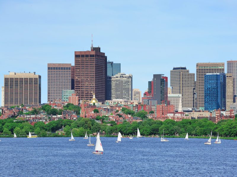 Boston skyline over Charles River with sailing boat.